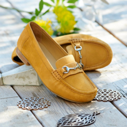 A pair of yellow loafers on a wooden floor